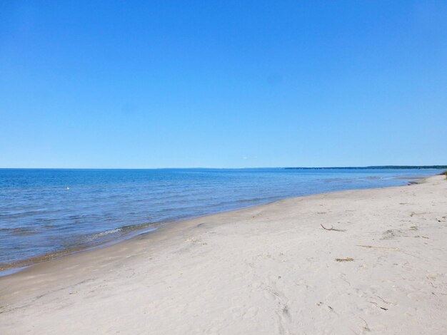 Scenic view of beach against clear blue sky