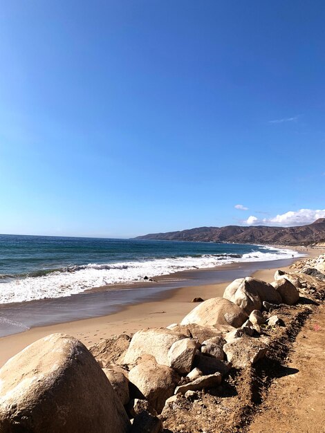 Scenic view of beach against clear blue sky