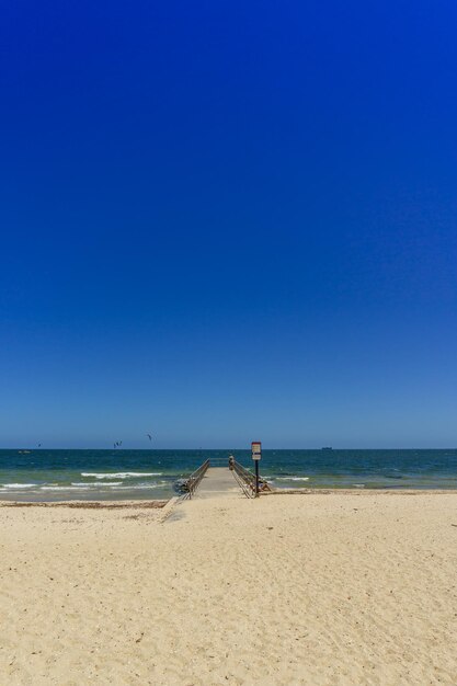 Scenic view of beach against clear blue sky