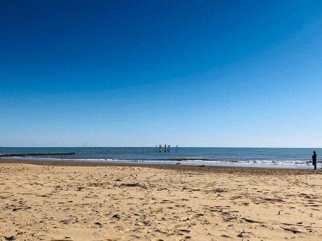 Scenic view of beach against clear blue sky