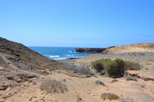 Scenic view of beach against clear blue sky