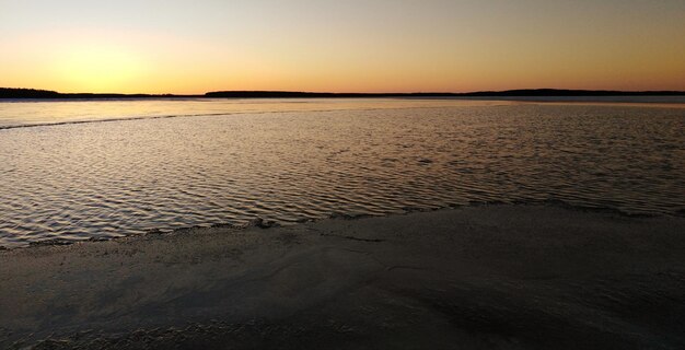 Scenic view of beach against clear sky during sunset