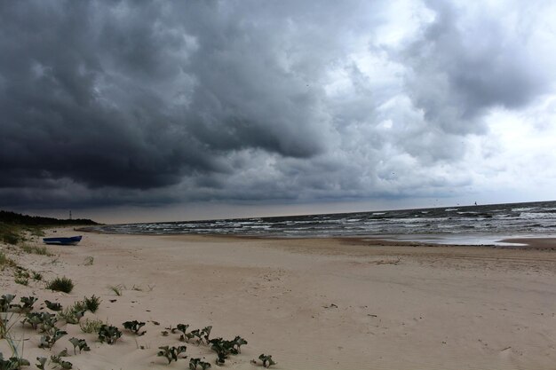 Scenic view of beach against cloudy sky