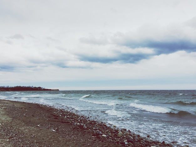 Scenic view of beach against cloudy sky