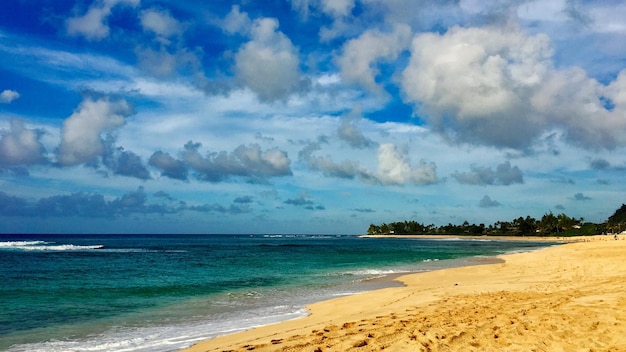Photo scenic view of beach against cloudy sky