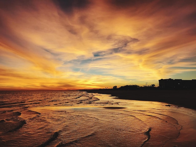 Foto vista panoramica della spiaggia contro un cielo drammatico durante il tramonto