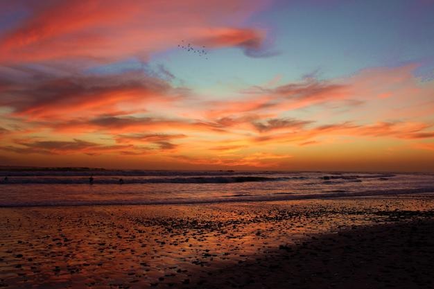 Photo scenic view of beach against orange sky