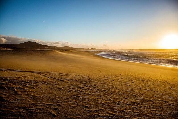 Photo scenic view of beach against sky during sunset