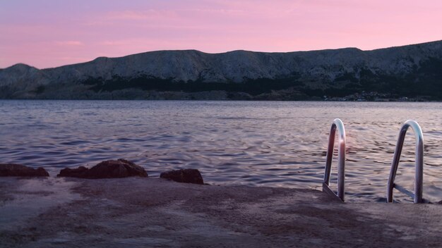 Photo scenic view of beach against sky during sunset