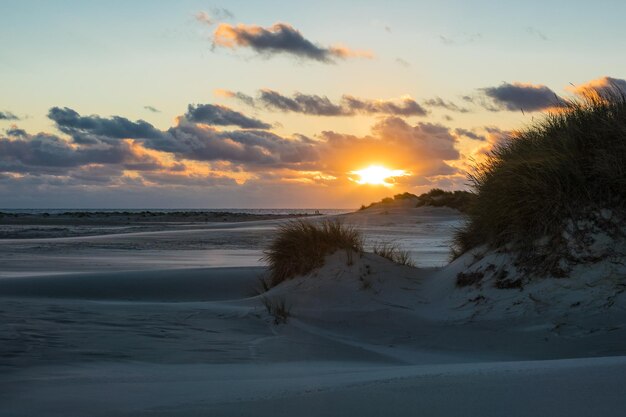 Photo scenic view of beach against sky during sunset