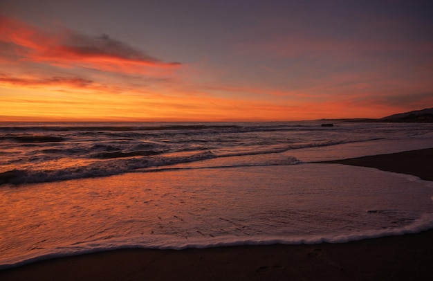 Photo scenic view of beach against sky during sunset