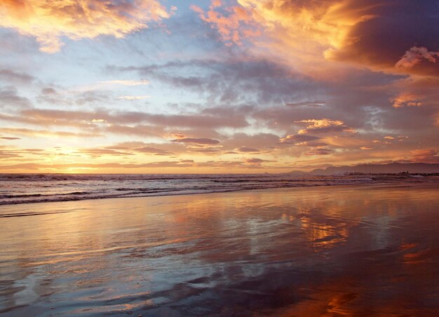 Photo scenic view of beach against sky during sunset