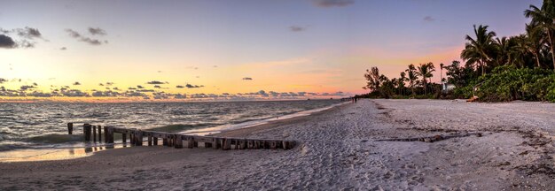 Photo scenic view of beach against sky during sunset