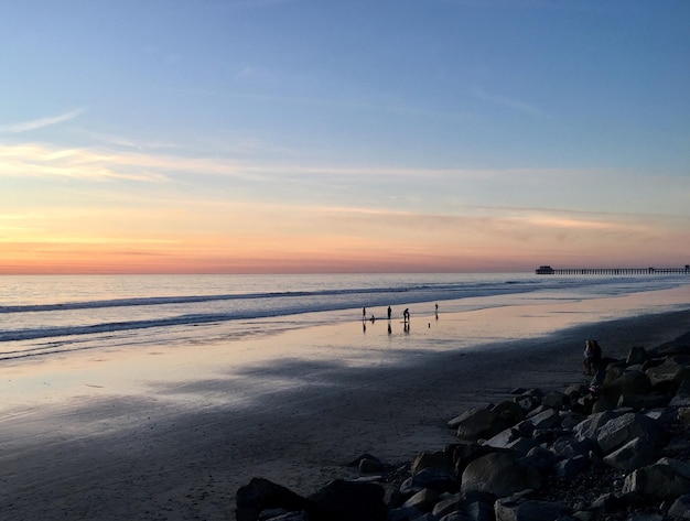 Photo scenic view of beach against sky during sunset