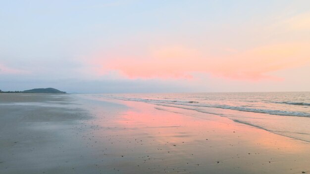 Photo scenic view of beach against sky during sunset