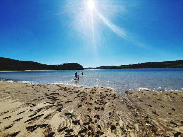 Scenic view of beach against sky on sunny day