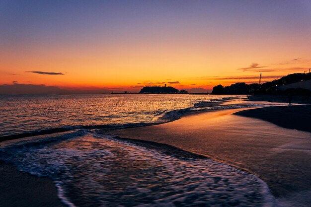 Photo scenic view of beach against sky at sunset