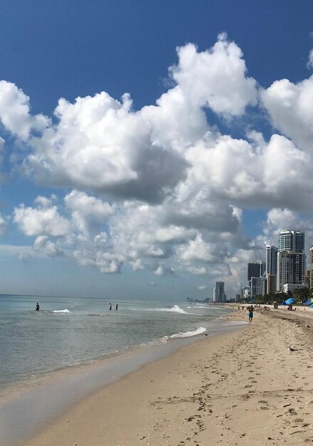 Photo scenic view of beach and buildings against sky