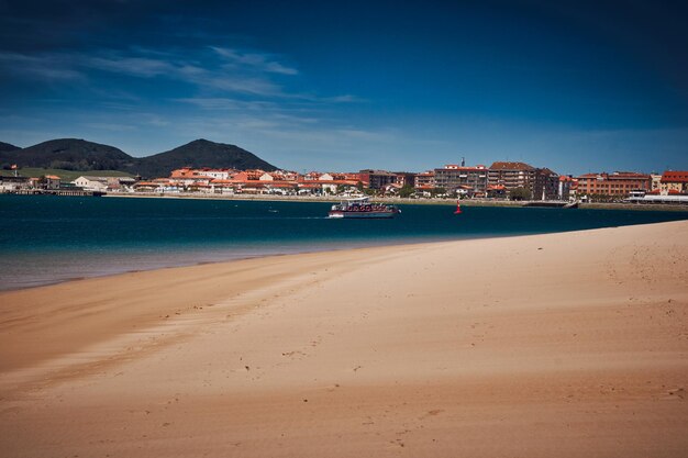 Scenic view of beach by buildings against blue sky