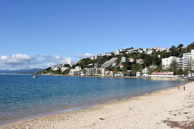 Scenic view of beach by buildings against sky