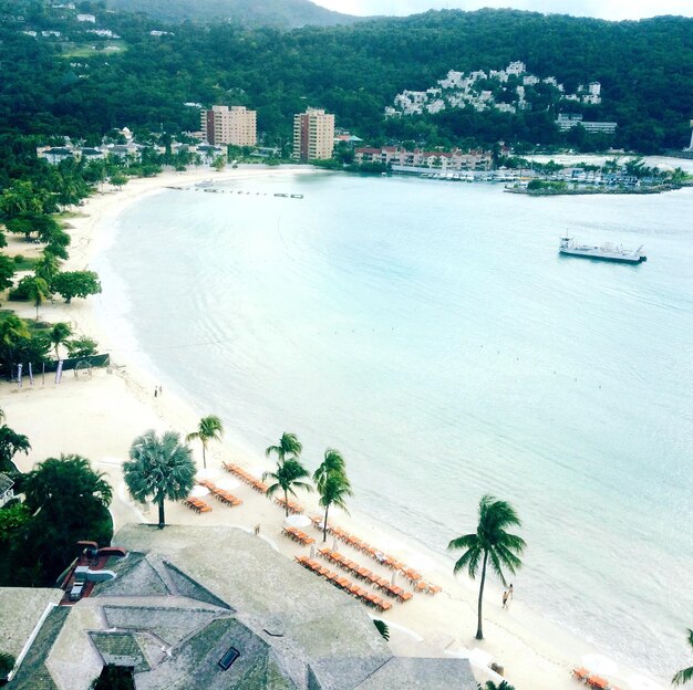 Scenic view of beach by city against sky