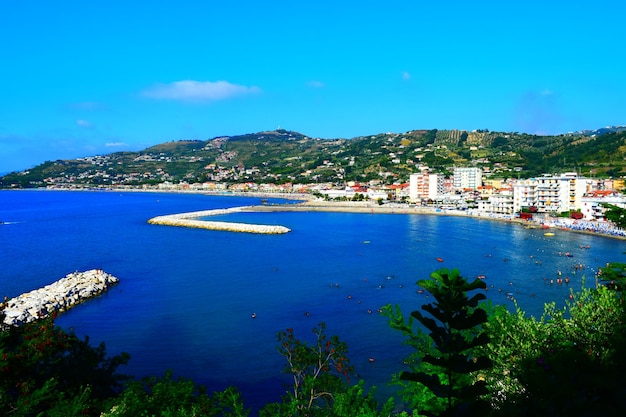 Scenic view of beach by mountain against sky