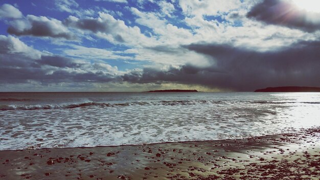 Scenic view of beach and sea against cloudy sky