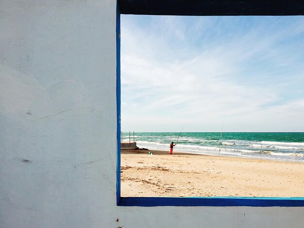 Scenic view of beach and sea seen through window