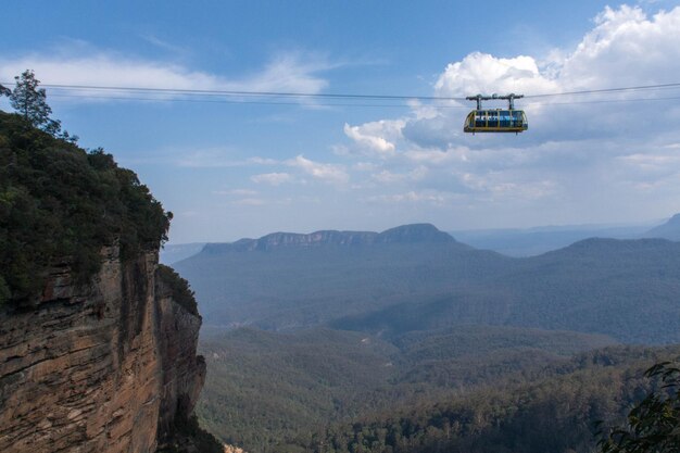 Scenic view of blue mountains against sky with cable car