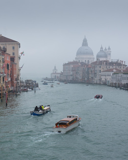 Photo scenic view of boats on a canal with numerous buildings in the backdrop