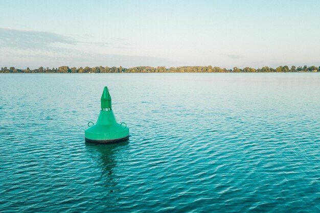 Scenic view of buoy in lake against sky