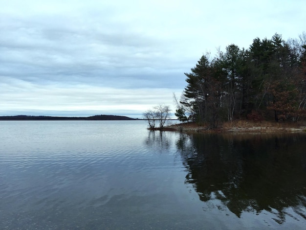 La vista panoramica del lago calmo contro un cielo nuvoloso