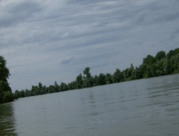 Scenic view of calm lake against cloudy sky