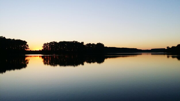 Scenic view of calm lake at sunset