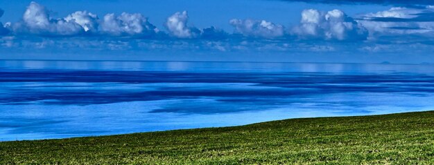 Photo scenic view of calm sea against cloudy sky