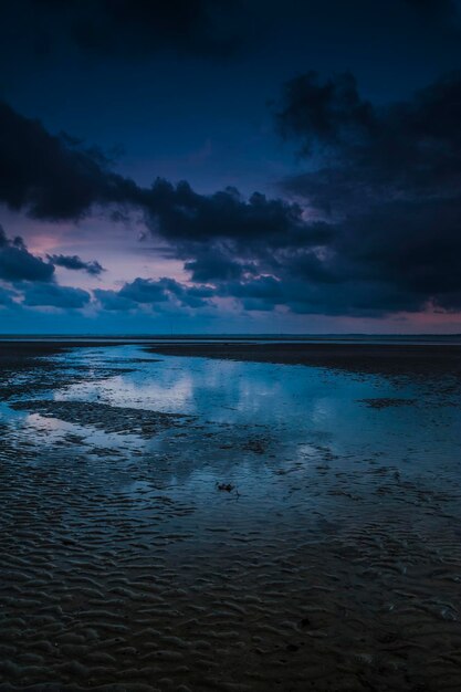 Scenic view of calm sea against cloudy sky