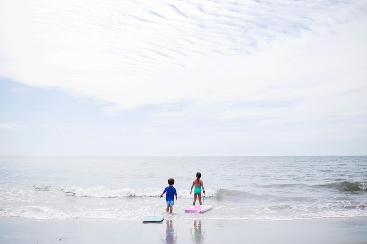 Photo 天空を背景に海を渡る子供たちの風景