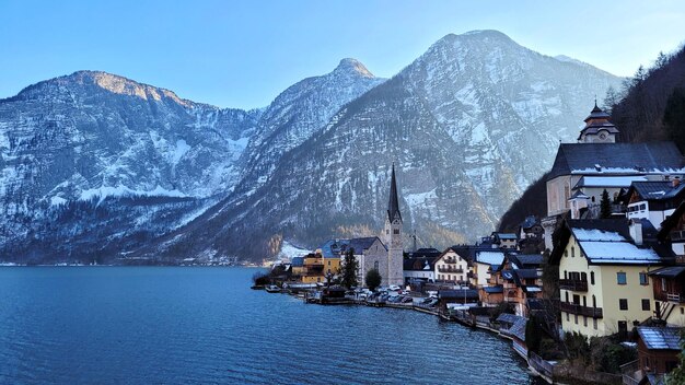 Photo scenic view of church and village against snowcapped mountains near the apline lake