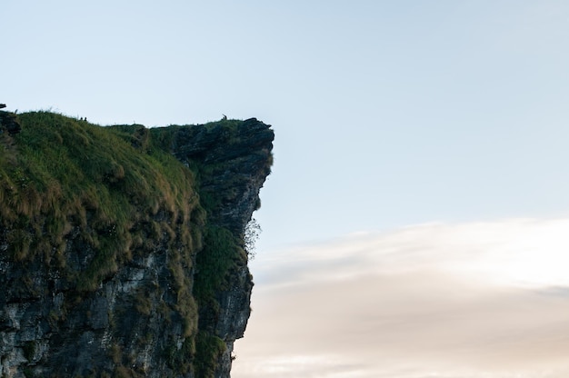 Scenic view of cliff by sea against sky