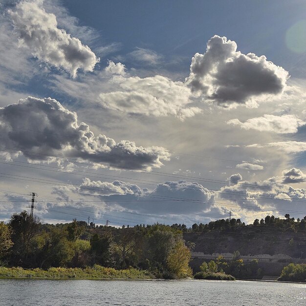 Photo scenic view of clouds over forest and river