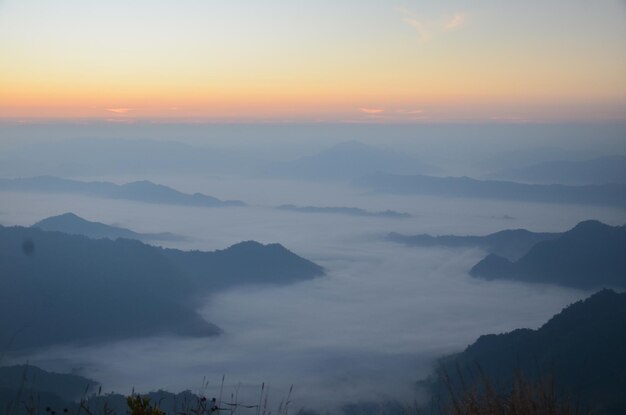 scenic view of clouds and mountains against sky during sunset