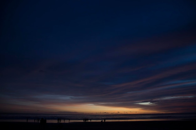 Scenic view of cloudy sky over beach at sunset