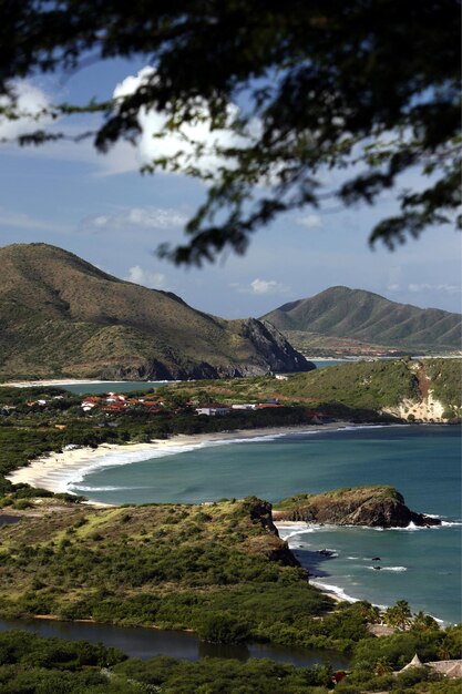 Photo scenic view of coastline and mountains against sky