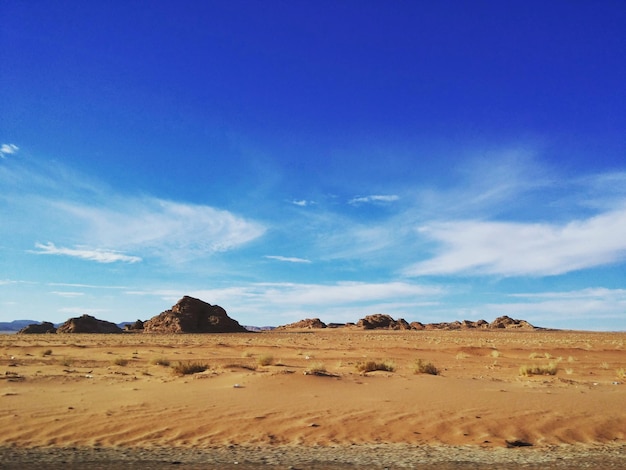 Scenic view of desert against blue sky