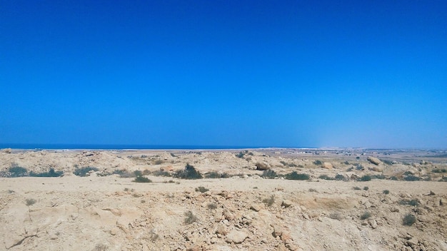 Scenic view of desert against clear blue sky