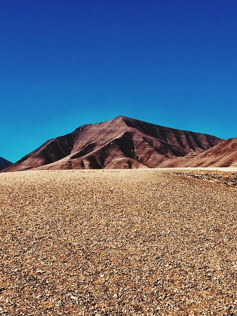 Scenic view of desert against clear blue sky