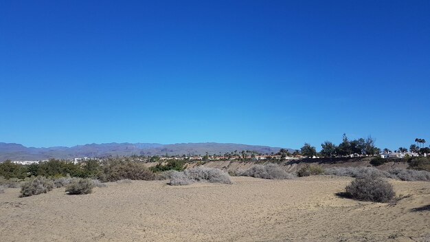 Scenic view of desert against clear blue sky