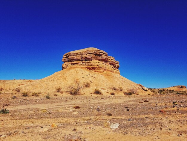 Scenic view of desert against clear blue sky