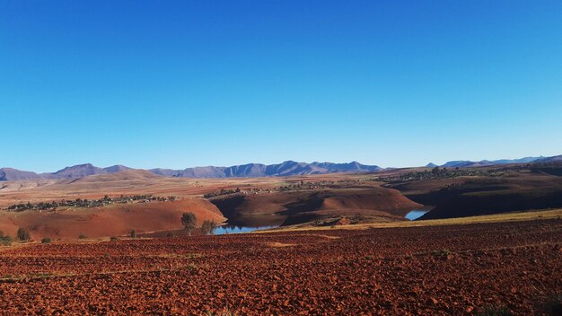 Scenic view of desert against clear blue sky