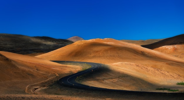 Photo scenic view of desert against clear blue sky